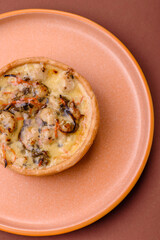 Pie or quiche, a sour tart with chicken and mushrooms, spices and herbs. Round quiche with chicken
