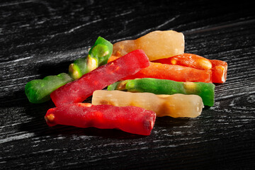 jelly sweets nuts on black wood background