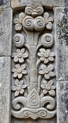 Stone carving of floral design on building exterior with weathered texture.