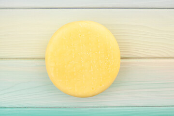 wheel of cheese on wood background top view