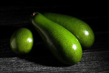 long avocado on wood black background