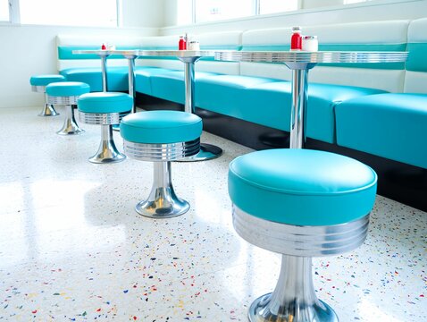 Retro diner booth seating with turquoise stools and chrome accents in a bright clean setting