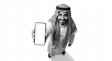 Saudi man in traditional attire holding blank smartphone, white background, studio shot.
