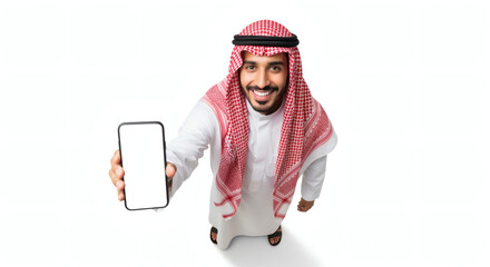 Saudi man in traditional attire holding blank smartphone, white background, studio shot.