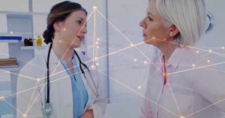 Consulting doctor discussing health with patient in consultation room, with stethoscope and shelves