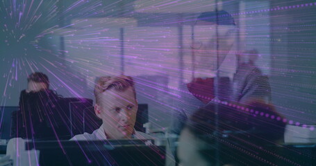 Collaborating modern office team reviewing monitors at workstations, purple light overlay