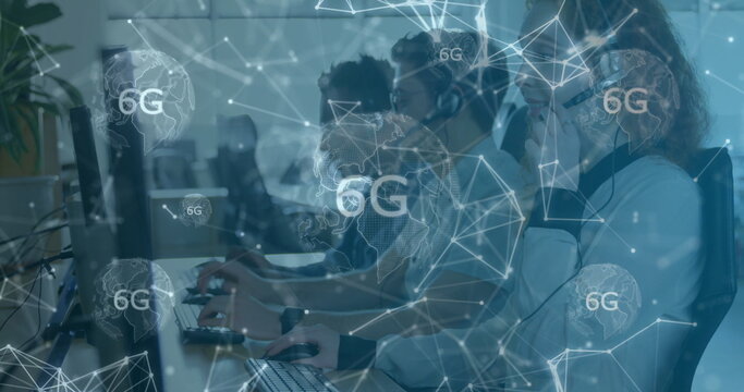 Collaborating IT specialists typing and speaking into headsets at workstations with 6G overlay