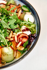 Fresh arugula salad with tomato, mozzarella, cucumber, pine nuts, and balsamic glaze