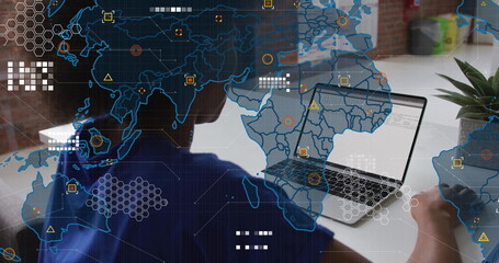 IT professional woman coding on laptop at desk in office, with digital world map overlay