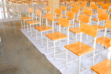 A lot of old wooden chairs and desks in workshop at school that have been renovated and given a shiny coat of shellac to make them last longer