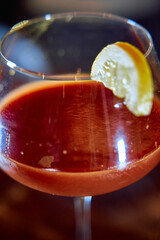 Refreshing red cocktail with citrus garnish in elegant glass