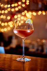Elegant cocktail glass with lemon garnish in warm ambient lighting