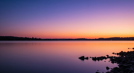 Obraz premium Serene lake at sunset with smooth water and colorful sky 