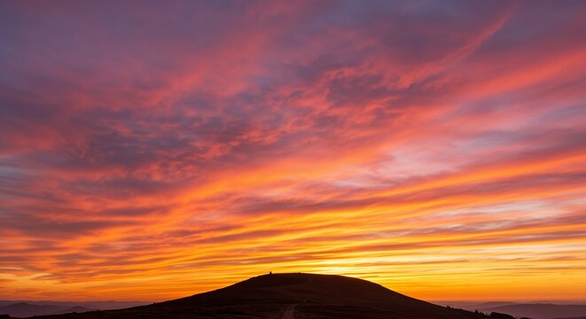 Colorful sunset sky over rolling hills with vivid clouds  