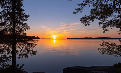 Beautiful sunset over a calm lake with silhouetted trees