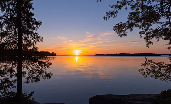 Beautiful sunset over a calm lake with silhouetted trees