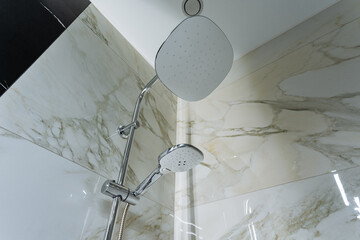 A shower head, which is a common plumbing fixture, is currently hanging from the ceiling in a...