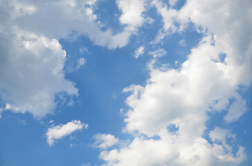 Bright blue sky with a frame of white clouds at the edges.