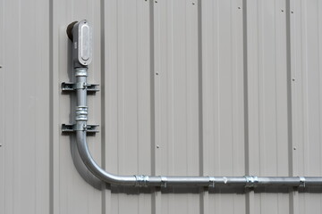 Metal building  with electrical conduit coming out.