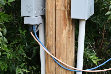 Extension cords plugged into power box on city power pole.