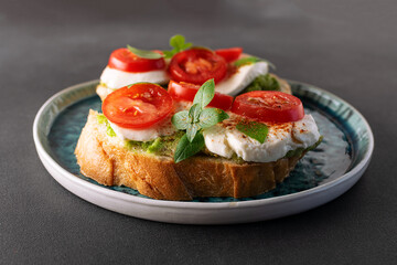 Fresh homemade caprese sandwich with avocado paste, mozzarella cheese, cherry tomatoes, fresh...