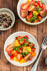 Fresh salad preparation with tomatoes and greens.