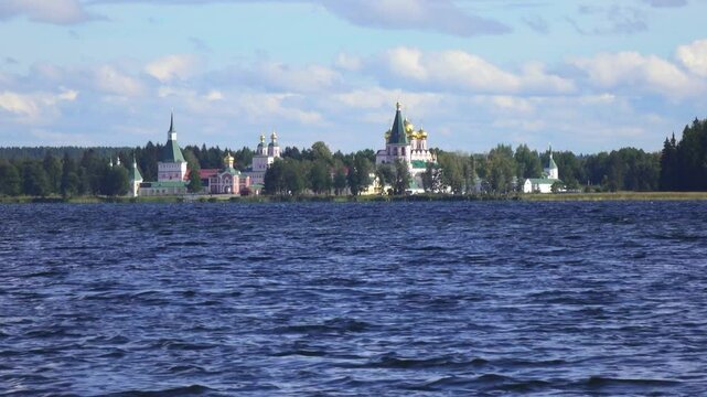View from the water at Valdai Iversky Svyatoozersky Virgin Monastery for Men. Selvitsky Island, Valdai Lake. View of the Valdai Iversky Bogoroditsky svyatoozersky monastery. Sunny June day,