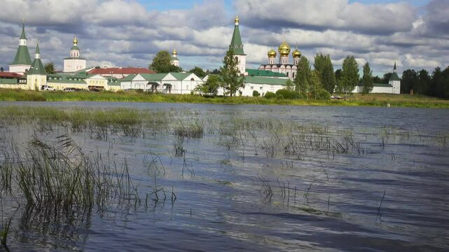 View from the water at Valdai Iversky Svyatoozersky Virgin Monastery for Men. Selvitsky Island, Valdai Lake. View of the Valdai Iversky Bogoroditsky svyatoozersky monastery. Sunny June day,