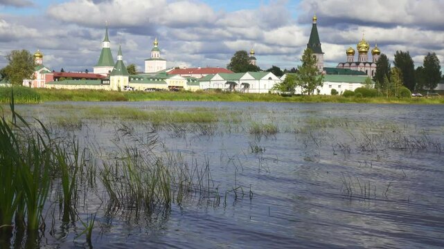 View from the water at Valdai Iversky Svyatoozersky Virgin Monastery for Men. Selvitsky Island, Valdai Lake. View of the Valdai Iversky Bogoroditsky svyatoozersky monastery. Sunny June day,