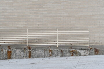 Metal railing on loading dock. Rust stains on cement.