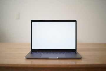 Fototapeta premium Laptop with Blank White Screen on Desk for Mockup Template Display