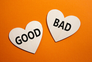 Good or Bad symbol. Concept word Good or Bad on wooden hearts. Beautiful orange background. Business and Good or Bad concept. Copy space