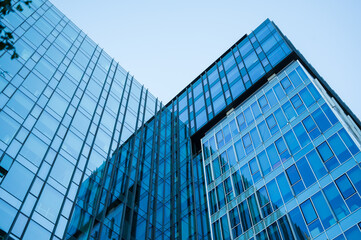 Close-up view of reflective blue glass office buildings creating an abstract architectural pattern....