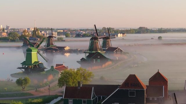 Aerial view of Dutch windmills and fog drifting over canal, Zaanse Schans
