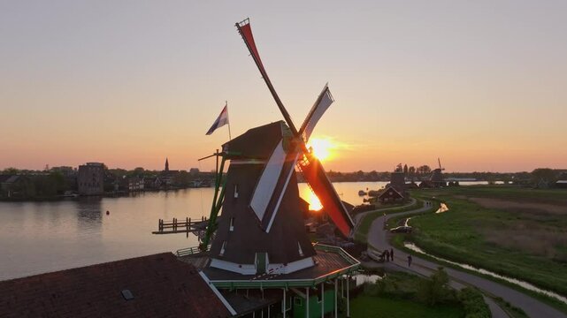 Aerial view of Zaanse Schans windmills glowing in festive sunset light