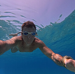 Tourist swimming underwater in the Mediterranean sea off the Sicilian coast. The man is forty years...