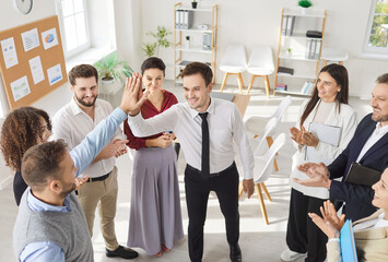 Group of business people standing in circle and making high five gesture as agreement, make deal or...