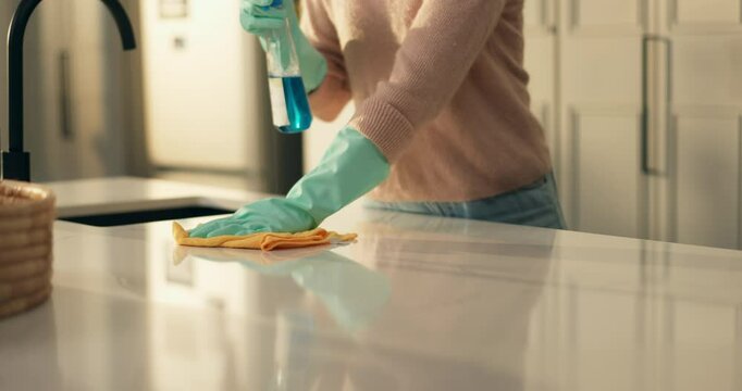 Hands, cloth and spray for cleaning, kitchen counter and disinfectant for germs in house. Person, gloves and bottle with liquid for bacteria, hygiene and routine for dust, shine and rag at apartment