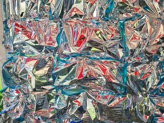 A background of crumpled silver foil with a red and blue sheen.