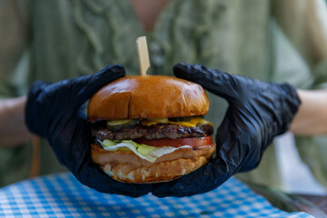 Deliciously Crafted Burger with Fresh Ingredients Topped with Pickles, Tomatoes, and Lettuce...