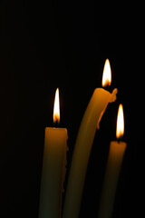 An Intimate Glimpse into the Flickering Flames of Three Candles in a Dark Setting, Illuminating the Surroundings with Warmth and Tranquility