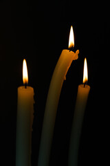 Three Elegant Candles with Gentle Flame Flickering in the Dark, Creating a Soothing and Serene...