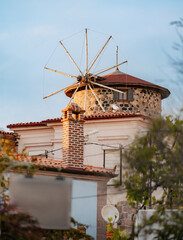 Picturesque view of a historic windmill overlooking the charming town of Ayvalik, Turkey,...