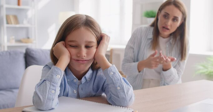Angry adult mother scolding little child boy for bad school results at home. Frustrated woman talking to tired upset boy during homework. Parent and children conflicts concept. 4k video.