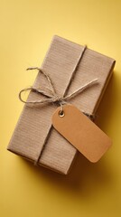 Rustic kraft gift box on mustard yellow background with empty tag for holiday sale promotion