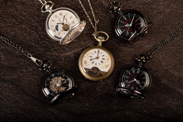 Pocket watch, beautiful old pocket watches on a dark surface, selective focus.