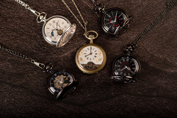 Pocket watch, beautiful old pocket watches on a dark surface, selective focus.