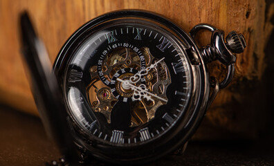 Pocket watch, beautiful old pocket watches on a dark and rustic wooden surface, selective focus.