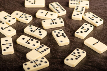 Dominoes, beautiful white domino pieces positioned on a dark background, selective focus.