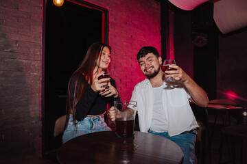 LGBT couple friends sitting and drinking beer in a bar happily